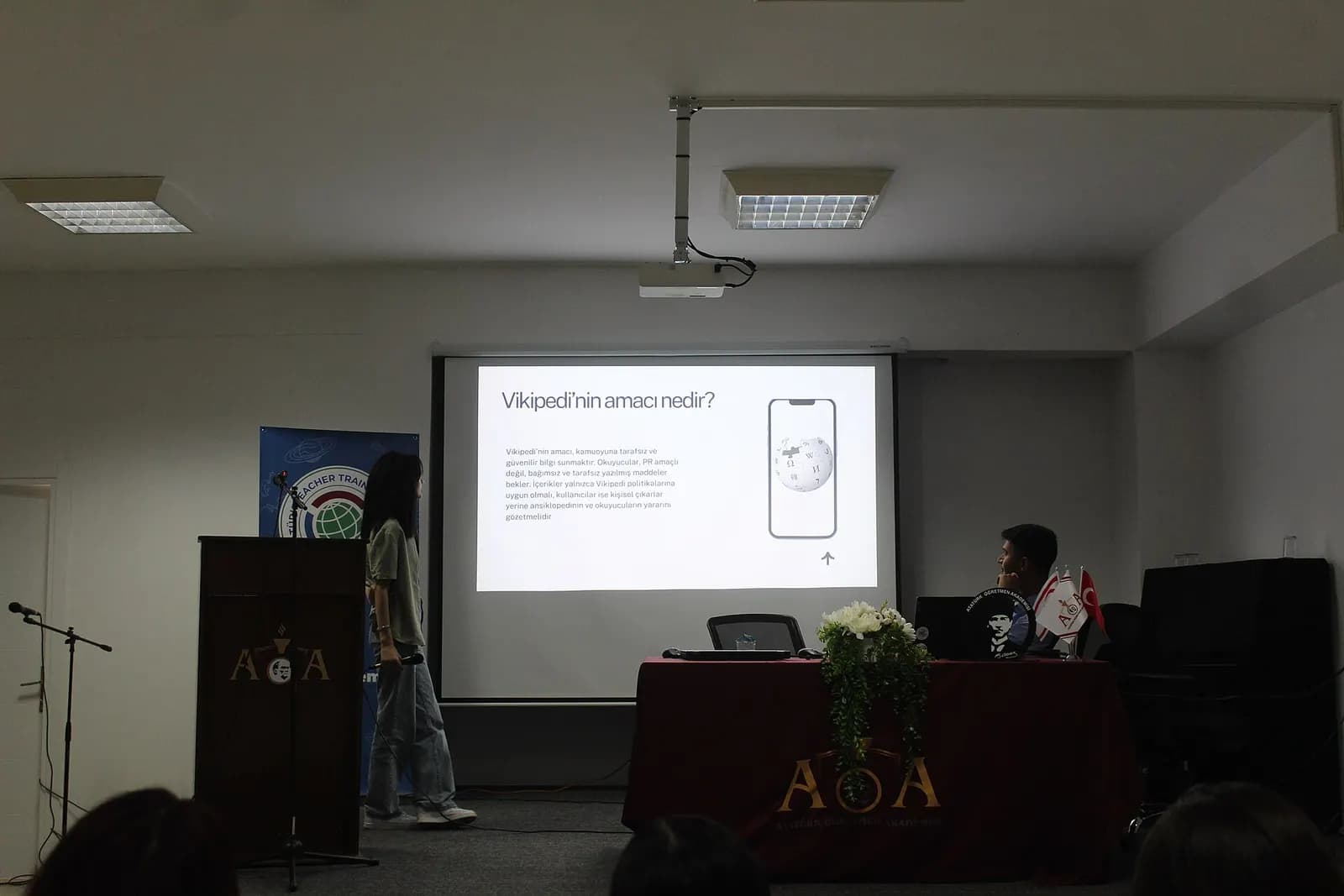Seminer salonunda perdeye yansıtılan bir sunum